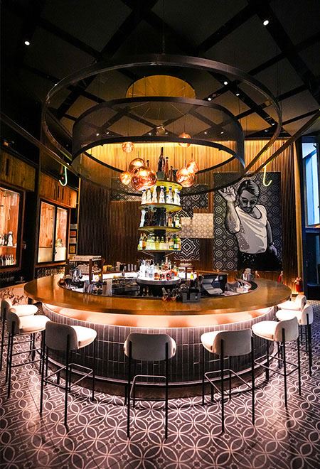 Stylish bar at Nusr-Et New York Midtown with iconic Salt Bae artwork and luxurious design, creating a vibrant atmosphere for cocktails and social events.