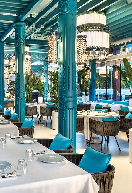 Stylish indoor dining at Nusr-Et Maçka Palas, featuring vibrant turquoise columns and elegant decor for a sophisticated steakhouse experience.