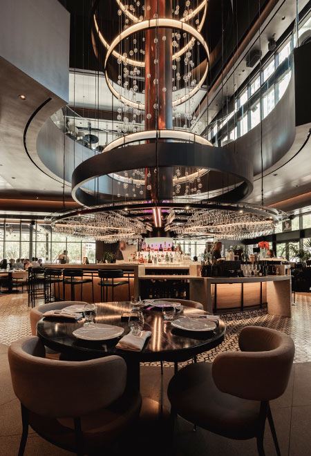 Elegant bar and dining space at Nusr-Et Las Vegas with a contemporary chandelier and modern lighting, offering a sophisticated steakhouse ambiance.