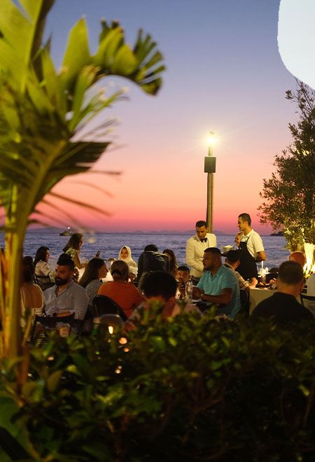 Outdoor dining at Nusr-Et Yalıkavak with a breathtaking sunset, offering guests a luxurious steakhouse experience by the sea.