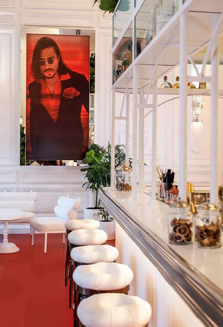 Chic bar area at Nusr-Et Maçka Palas, featuring a stylish portrait of Nusret Gökçe and sophisticated white decor for an upscale dining experience.